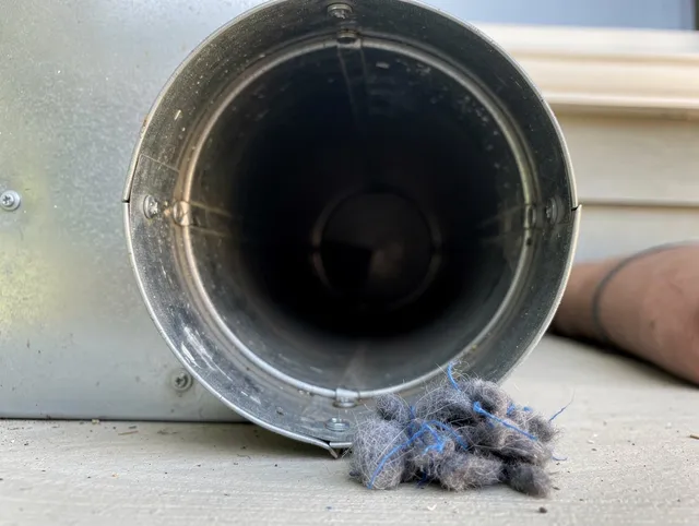 Matthews Dryer Vent Cleaning technician using specialized equipment to clear severe dryer vent blockage in Matthews